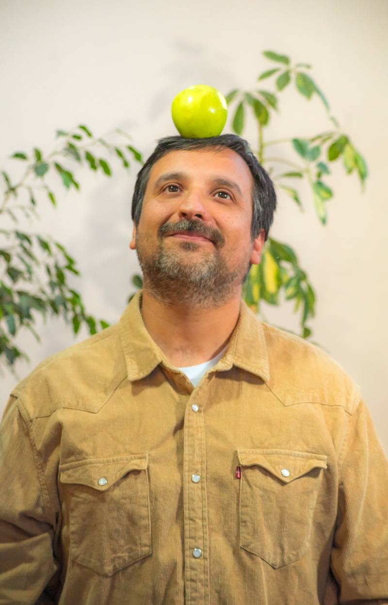 Joaquín sonríe con una manzana verde sobre la cabeza